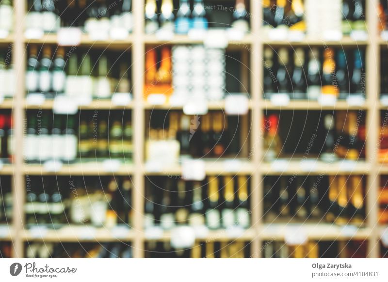 Unscharfes Bild von Flaschen mit Alkohol in den Regalen im Supermarkt. Wein Getränk Hintergrund abstrakt Einzelhandel Werkstatt Laden Weingut Ablage Markt Reihe