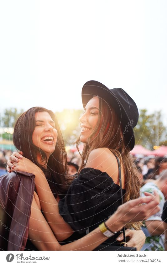 Lächelnde, modische Frauen, die in der Nähe bleiben Stadtfest Feier Leder Menschengruppe Jacke Partnerschaft selbstbewusst Zusammensein Feiertag Freundschaft