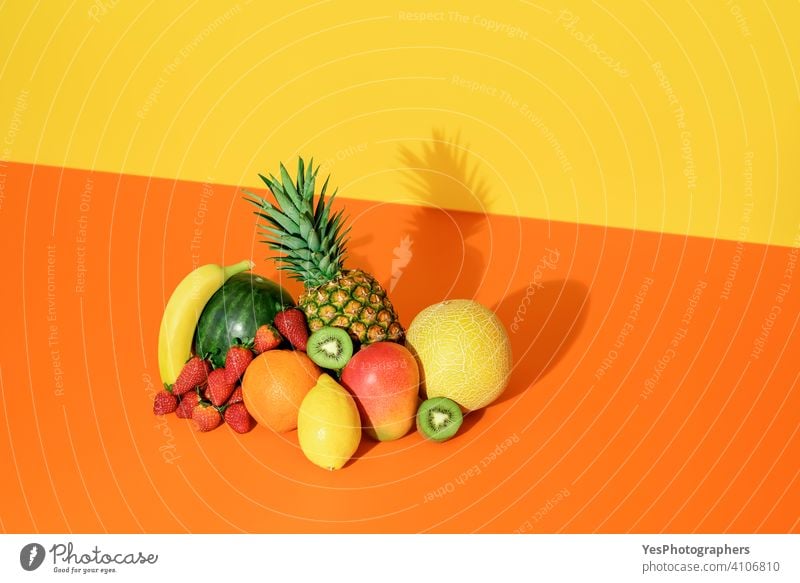 Tropische Früchte isoliert auf einem farbigen Hintergrund. Frische Sommerfrüchte. Ananas sortiert Banane Kantalupe Zitrusfrüchte farbenfroh Farben Textfreiraum