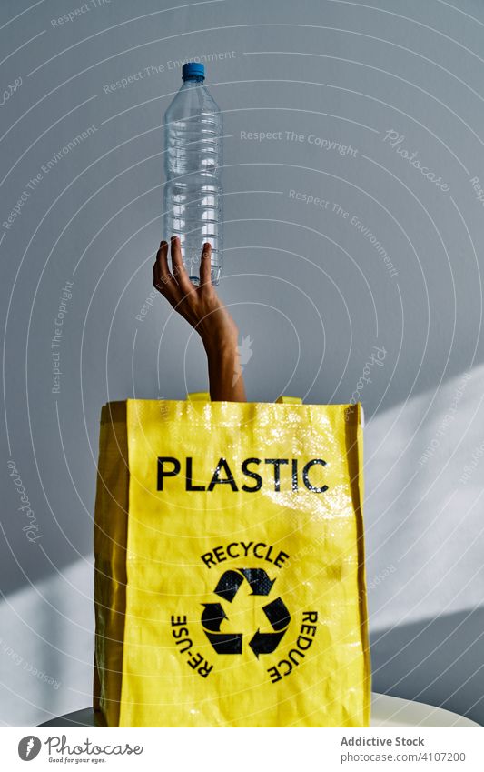 Anonyme Person hält Plastikflasche im Studio Kunststoff Flasche rausstrecken Tasche Hand Wasser leer wiederverwerten Müll Umwelt verseucht Abfall Problematik
