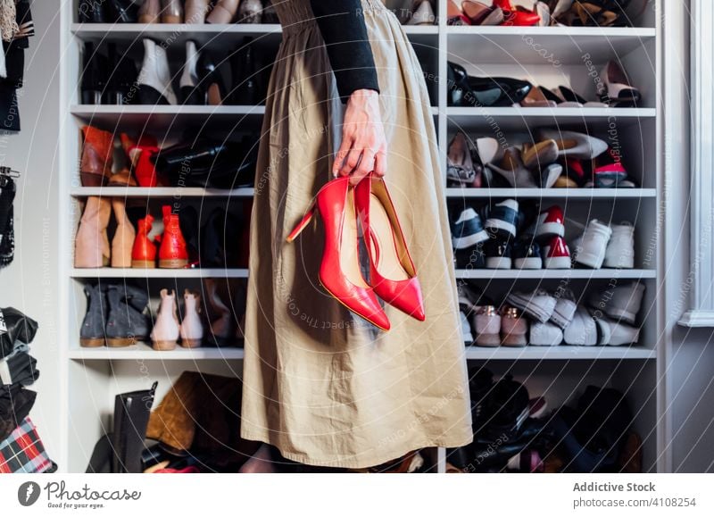 Anonyme Frau mit hochhackigen Schuhen im Kleiderschrank Damenschuhe wählen trendy Mode Stil Outfit modern Brille verschiedene Glamour Accessoire elegant lässig