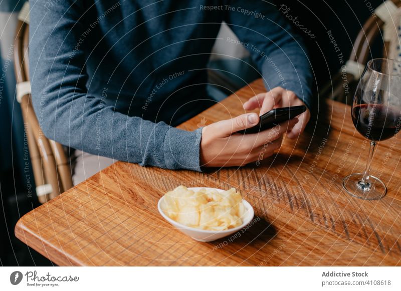 Mann benutzt Smartphone in einem Cafe benutzend Café Tisch Telefon Wein trinken ruhen sich[Akk] entspannen männlich Getränk Restaurant lässig Gerät Apparatur