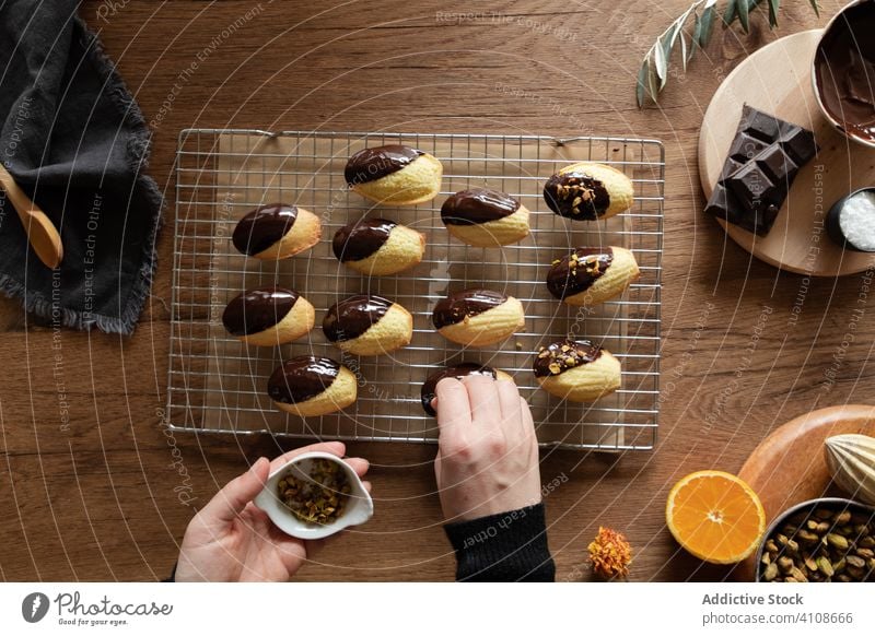 Frau bestreut Madeleine-Kekse mit Nüssen madeleine Rezept Nut Schokolade bestäuben Garnierung dekorieren Lebensmittel Bestandteil Hand süß Dessert lecker