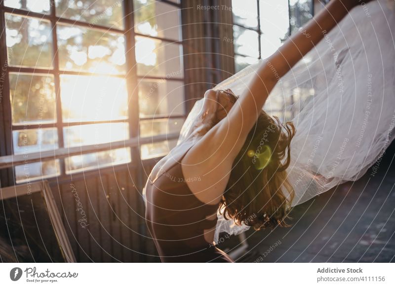 Schlanke Frau tanzt mit Schleier im hellen Studio Tanzen Anmut Ballerina expressiv Imkerschleier Leidenschaft sinnlich beweglich schlank Bewegung Rückbiegung