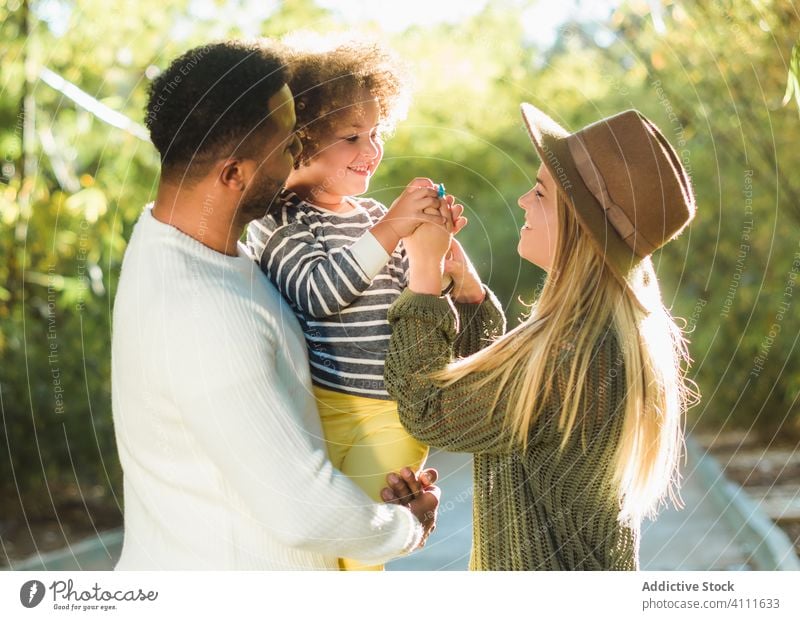 Glückliche Familie hat Spaß im Park Zusammensein Liebe Kind Umarmen heiter Spaß haben Sommer Eltern Bonden Lächeln Zuneigung Partnerschaft Mutter Vater Kindheit