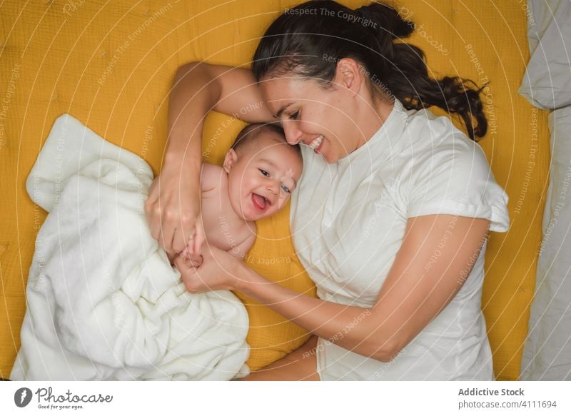 Überglückliche Mutter liegt mit Baby Lügen Lachen Lächeln Zusammensein genießen Kind bezaubernd wenig unschuldig niedlich Glück Liebe Eltern Zuneigung ruhen