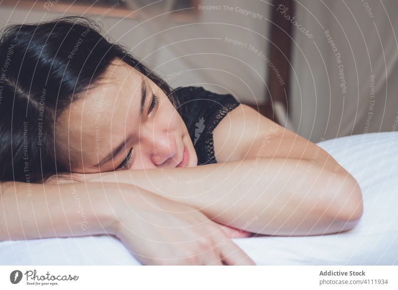 Glückliche ethnische Frau auf dem Bett liegend Lügen heimwärts Morgen sich[Akk] entspannen Schlafzimmer Komfort ruhen gemütlich Zuneigung jung Freude Lifestyle