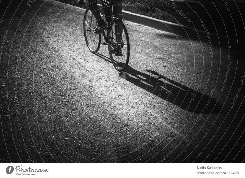 Schatten eines Mannes, der auf der Straße Fahrrad fährt. Aktion Aktivität Asphalt Gleichgewicht Radfahren Erwachsener Großstadt niedlich Zyklus Übung Spaß