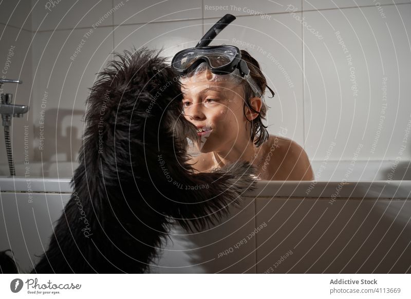 Glücklicher Junge mit seinem Hund in der Badewanne duschend Wasser Dusche Kindheit heimwärts wenig Sauberkeit Kaukasier Lifestyle Hygiene Fröhlichkeit Lächeln