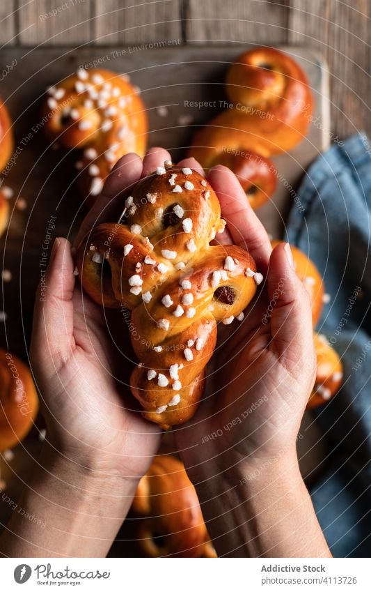 Person mit leckeren hausgemachten Brötchen Lebensmittel backen selbstgemacht Hand geschmackvoll Gebäck süß Safran Tradition frisch Ernährung appetitlich essen