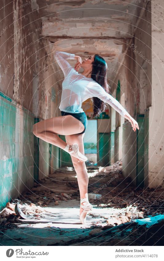 Junge Ballerina tanzt in schmutzigem Korridor Frau Tanzen Balletttänzer Anmut Konzept Grunge Verlassen Gang jung schlank elegant aufschauend abbrechen ausführen