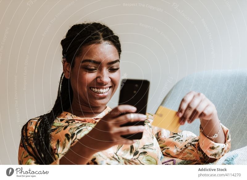 Ethnische Frau, die zu Hause online einkauft Smartphone Kreditkarte Werkstatt Zahlung Kauf heimwärts benutzend Gerät Apparatur Lächeln Glück Internet Käufer