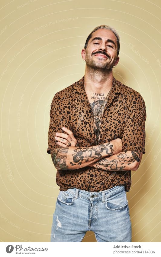 Trendiger ethnischer Typ in modischem Outfit im Studio stehend Mann trendy Stil heiter Mode Leopard Model Jeanshose männlich Stoff modern cool selbstbewusst