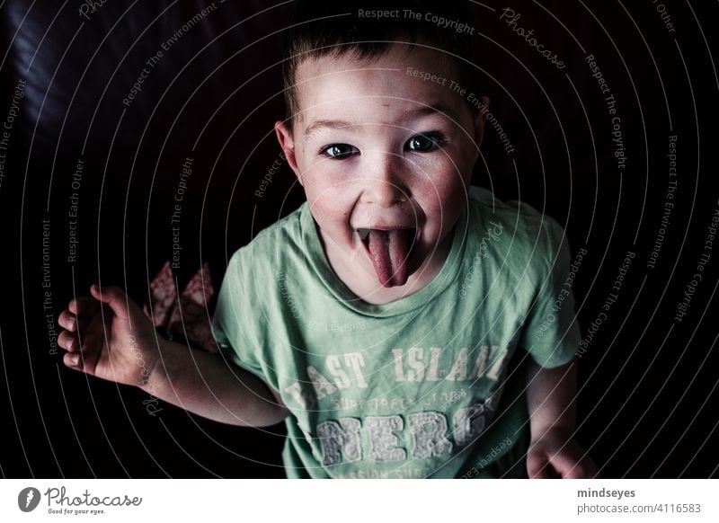 Frecher Junge Kindheit frech Zunge rausstrecken zunge zeigen Porträt lustig Gesicht Grimasse Blick in die Kamera Fröhlichkeit wild