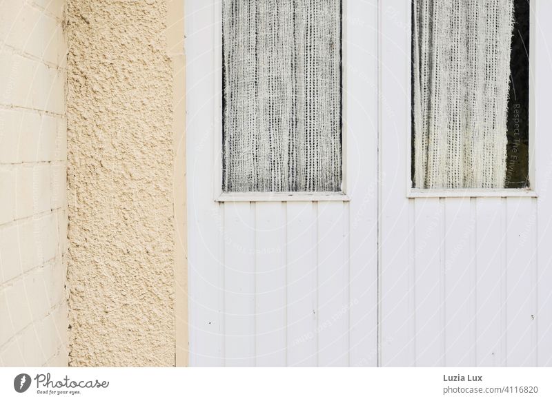 Eine alte Hintertür in zarten Farben, Fenster mit Gardine gelb beige weiß Holz Mauer Menschenleer Außenaufnahme Häusliches Leben Tag Vorhang Licht Sonnenlicht