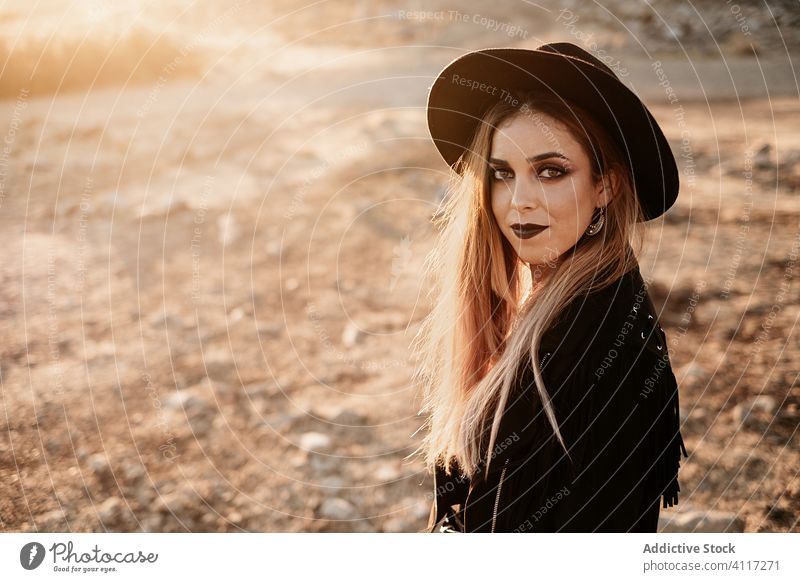 Stilvolle Frau steht auf Fels in der Landschaft Stein Sonnenuntergang Hut Spaziergang Outfit Schleim Model schwarz trendy Natur Felsen Felsbrocken Abend