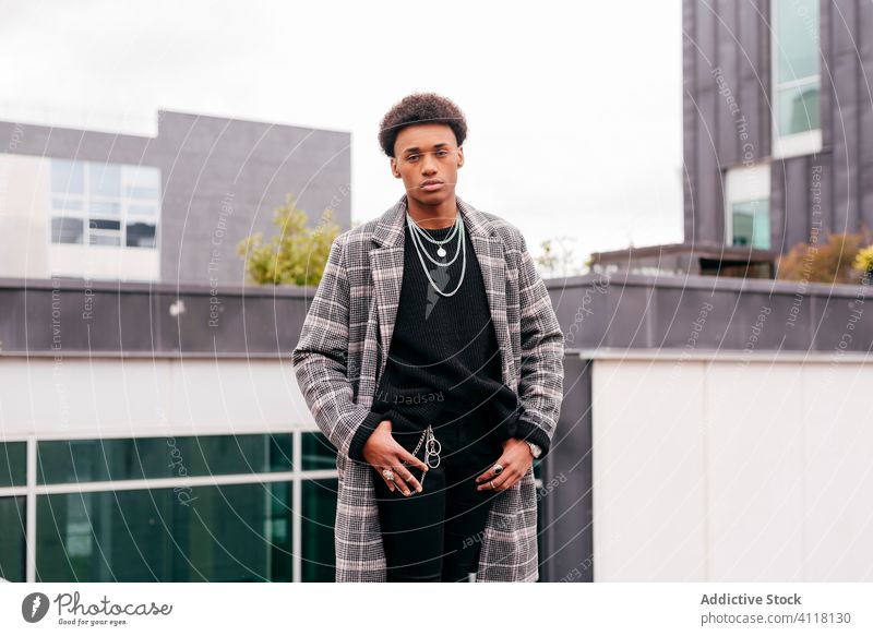 Selbstbewusster junger Mann in modischem Mantel auf der Straße Stil trendy Mode urban cool Model Großstadt Gebäude Herbst ernst modern Afroamerikaner schwarz