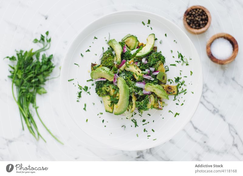 Frisches Petersiliengrün und Brokkoli in Avocadosalat Salatbeilage Teller Zucchini Gemüse dienen frisch Vegetarier Koriander Küche rund Gewürz lecker Portion