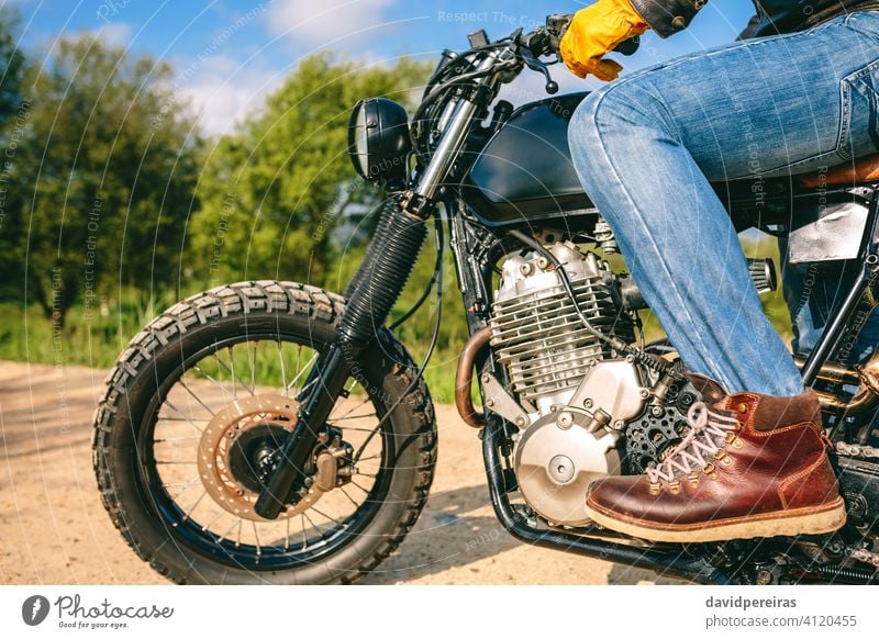 Mann auf einem Custom-Motorrad unkenntlich Reiten benutzerdefiniert Profil altehrwürdig Handschuhe Beteiligung packend Lenker gestoppt Fahrrad cool erbaut