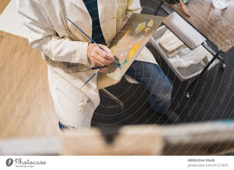 Älterer Mann malt Bild mit Pinsel Künstler gealtert Pinselblume Kunst heimwärts Inspiration zeichnen Farbe Konzentration Palette Erdöl Staffelei Papier Atelier