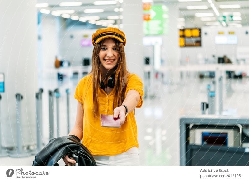 Junge glückliche Studentin beim Einchecken für einen Flug am Flughafen Frau Reisepass Registrierung einchecken Passagier Abheben froh trendy farbenfroh Terminal