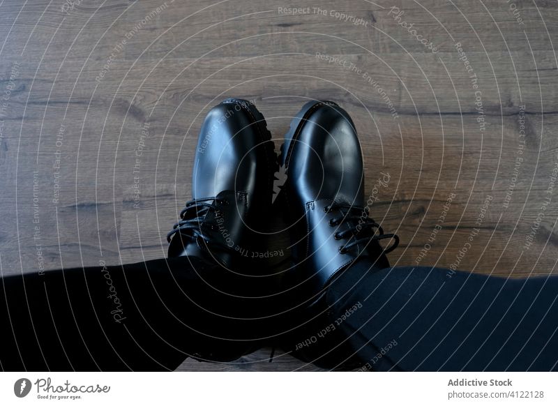 Crop Mann in stilvollen glänzenden Schuhen brutal schwarz modern Stil Sauberkeit Stiefel hölzern Sohle Stock lässig männlich ordentlich heimwärts sitzen Hose