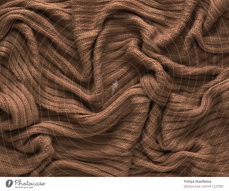 Brown zerknittert gestrickten Schal oder Pullover Textur, Ansicht von oben. Textur Hintergrund der warmen gehäkelte Kleidung Textil. Strickwaren Stoff. stricken