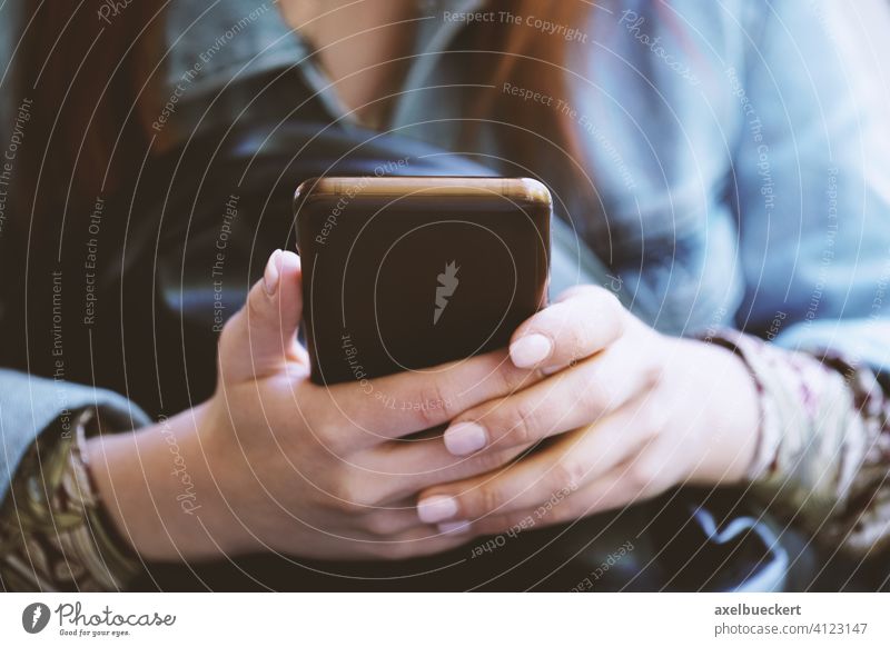Hände einer nicht erkennbaren jungen Frau, die ein Smartphone oder Mobiltelefon benutzt Handy benutzen Telefon benutzend Technik & Technologie Texten digital