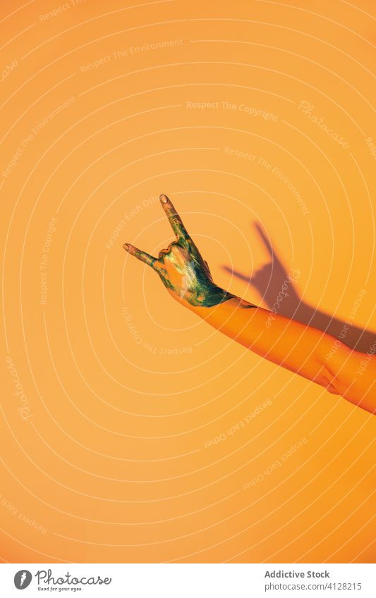 Frau mit gemalter Hand, die ein Hornzeichen zeigt Rock and Roll Zeichen Felsen Farbe gestikulieren zeigen Symbol metallisch kreativ Konzept Hupe farbenfroh