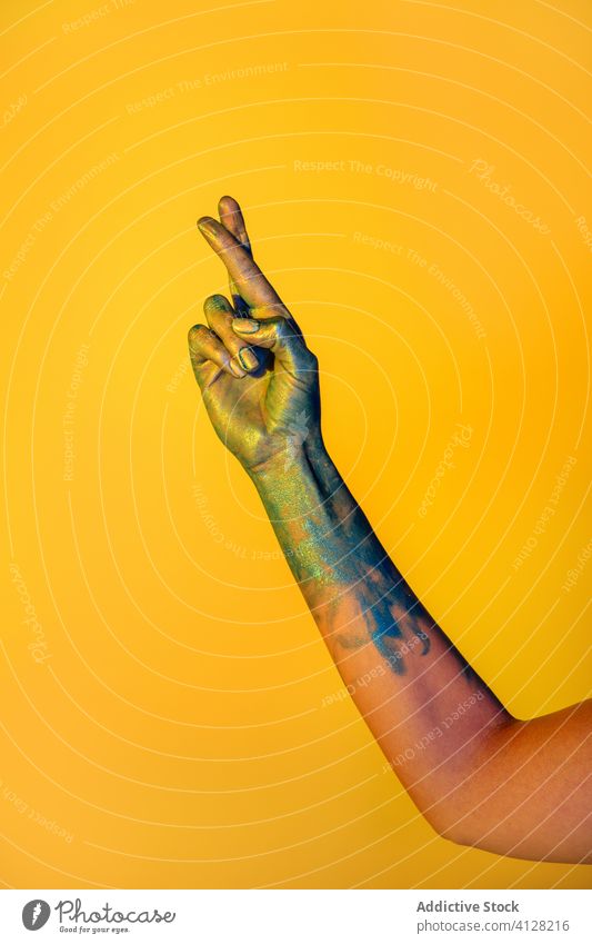 Crop-Frau schnippt mit den Fingern im Studio zerspringen Farbe gestikulieren zeigen Zeichen kreativ Kunst Konzept metallisch Symbol farbenfroh abstrakt