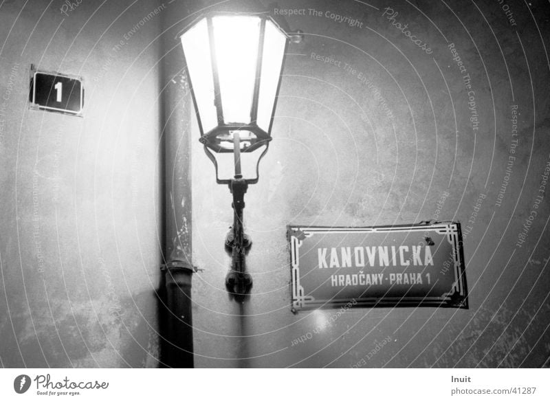 Laterne Straßenbeleuchtung Prag Straßennamenschild Nacht obskur Schwarzweißfoto TIF Kafka