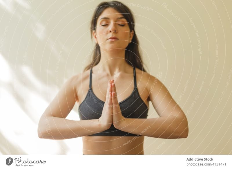 Ruhige Frau meditiert in Lotus-Pose meditieren Yoga Namaste padmasana Achtsamkeit ruhig Fokus heimwärts Konzentration Übung Unterlage Training Gelassenheit