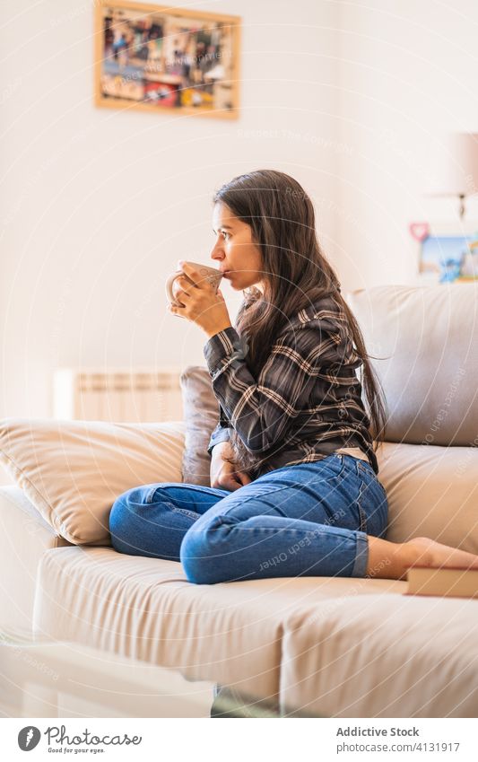 Junge Frau mit einer Tasse Kaffee auf dem Sofa liegend heimwärts ruhen Windstille besinnlich jung trinken lässig gemütlich Liege sich[Akk] entspannen Komfort