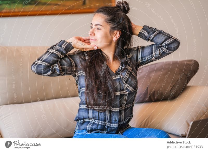 Positive Frau, die ihren Körper während der Arbeit mit einem Laptop dehnt heimwärts Dehnung ruhen jung lässig freiberuflich sich[Akk] entspannen Pause Sofa