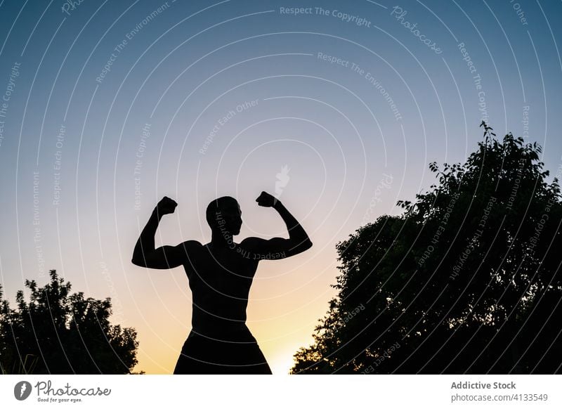 Athletischer schwarzer Mann trainiert im Park Afrikanisch muskulös Silhouette Fitness stark Biegung Körper passen Muskel Bizeps Waffen Stärke Lifestyle Truhe