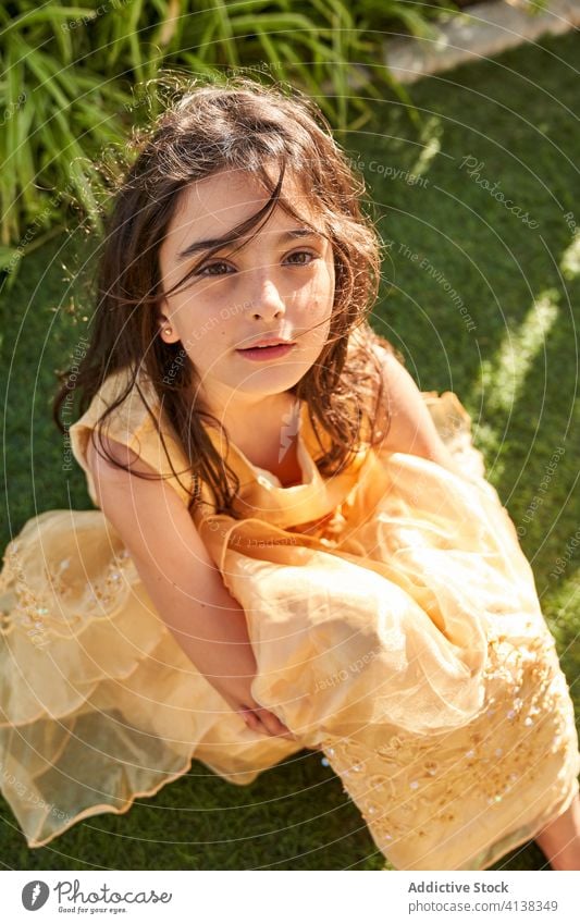 Charmantes kleines Mädchen im Kleid auf Gras sitzend Sommer Lächeln bezaubernd Kind ruhen Porträt Kindheit Windstille wenig Glück ruhig niedlich charmant