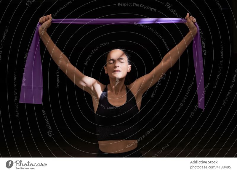 Konzentrierte sportliche Frau beim Üben mit dem Widerstandsband Sportlerin elastisch Band Training Fitnessstudio Athlet üben widersetzen Konzentration schlank
