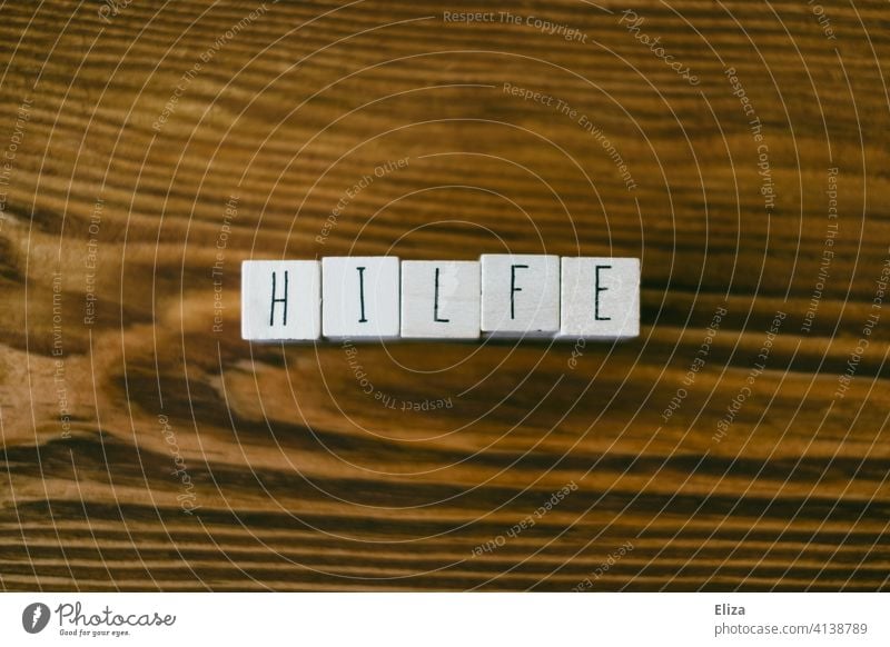 Das Wort Hilfe mit Buchstabenwürfeln auf Holz geschrieben helfen hilfreich Unterstützung SOS Hilfsbereitschaft Notfall Erste Hilfe Zuspruch füreinander Notruf