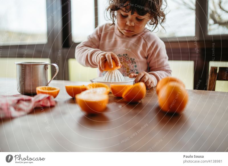 Kind macht Orangensaft zu Hause 1-3 Jahre Kaukasier Farbfoto authentisch orange Vorbereitung Frucht Mensch Kindheit Kleinkind Lifestyle Gesundheit mehrfarbig