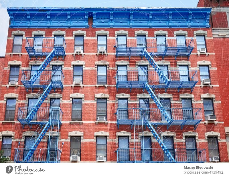 Altes rotes Backsteingebäude mit blauen Eisen Feuerleitern, New York City, USA. New York State Großstadt Gebäude Manhattan alt Feuertreppe Haus neu Appartement