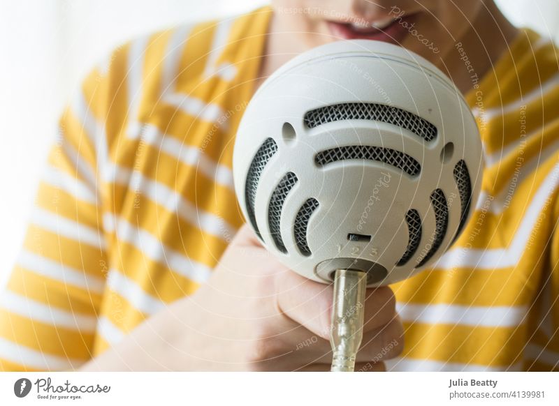 Frau spricht in ein weißes Mikrofon; Tonaufnahme Podcast Aufzeichnen singen Musik ausführen Künstlerin Sprachausgabe Stimme lesen Skript Atelier Radio Blogger