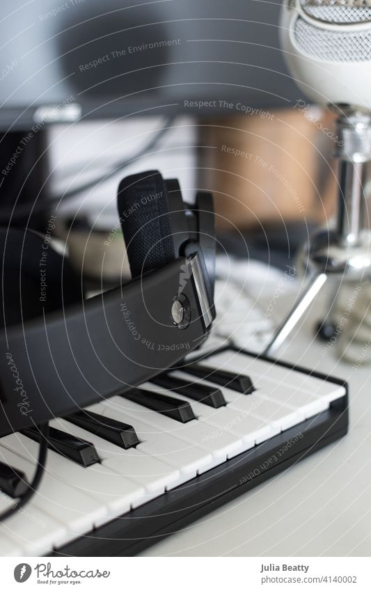 Einrichtung des Computertisches eines Musikers: Tastatur, Kopfhörer und Mikrofon vor einem Monitor Gerät dj Audio Technik & Technologie Klang Atelier Büro