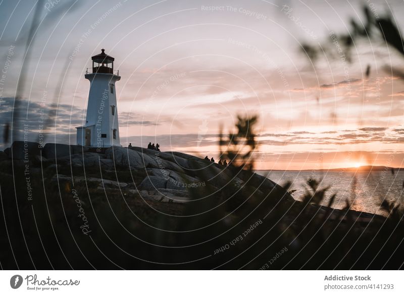 Unbekannte Menschen bewundern den Sonnenuntergang in der Nähe des Leuchtturms MEER Himmel wolkig Silhouette Peggys-Bucht Kanada reisen ruhen Felsen Küste Abend