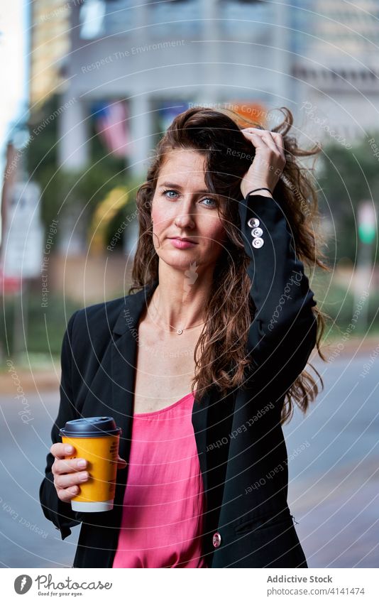 Selbstbewusste Frau mit Kaffee zum Mitnehmen auf der Straße Imbissbude Geschäftsfrau Pause Großstadt Erfrischung Unternehmer selbstbewusst elegant Jacke