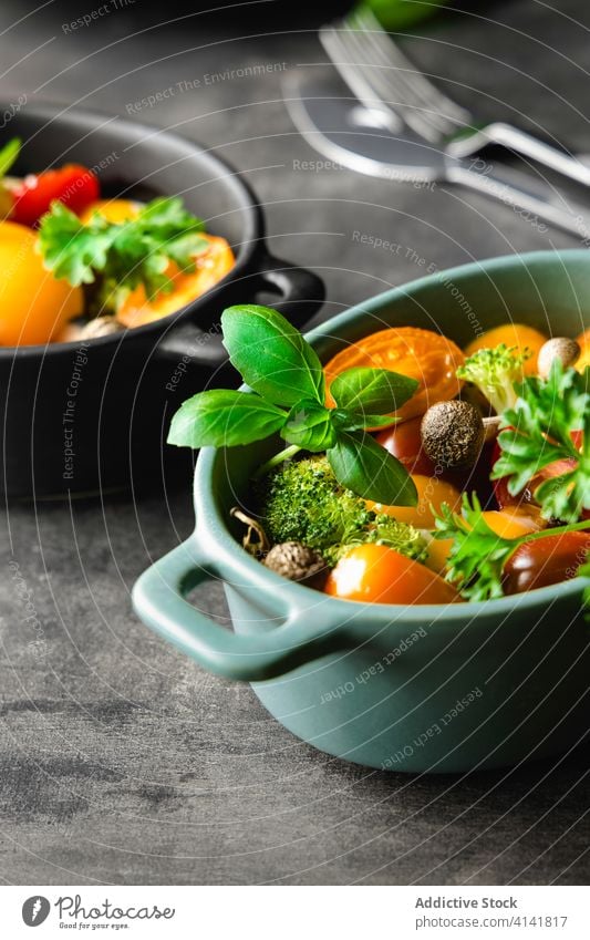 Frischer Salat in Schüsseln auf dem Tisch Gemüse Salatbeilage frisch Schalen & Schüsseln Bestandteil verschiedene Tomate Pilz Basilikum Rosmarin geschmackvoll