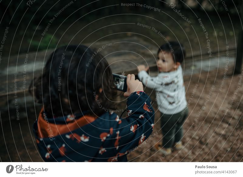 Junges Mädchen, das ein Foto von ihrem kleinen Bruder macht Geschwister Kind 1-3 Jahre Kaukasier Kindheit digital Digitalfotografie Fotokamera