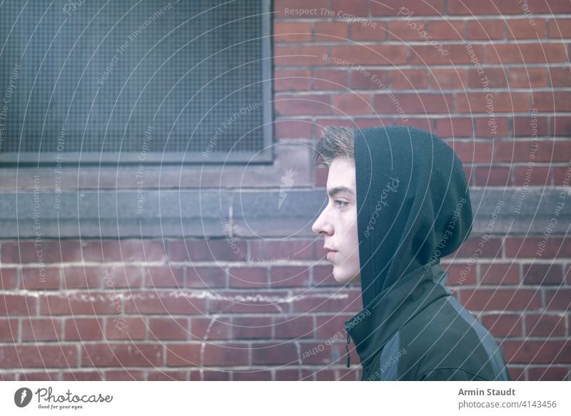 Porträt eines jungen Mannes im Profil mit Kapuzenpulli schön Junge Baustein lässig Kaukasier selbstbewusst cool gehen gutaussehend Bild Lifestyle Blick männlich