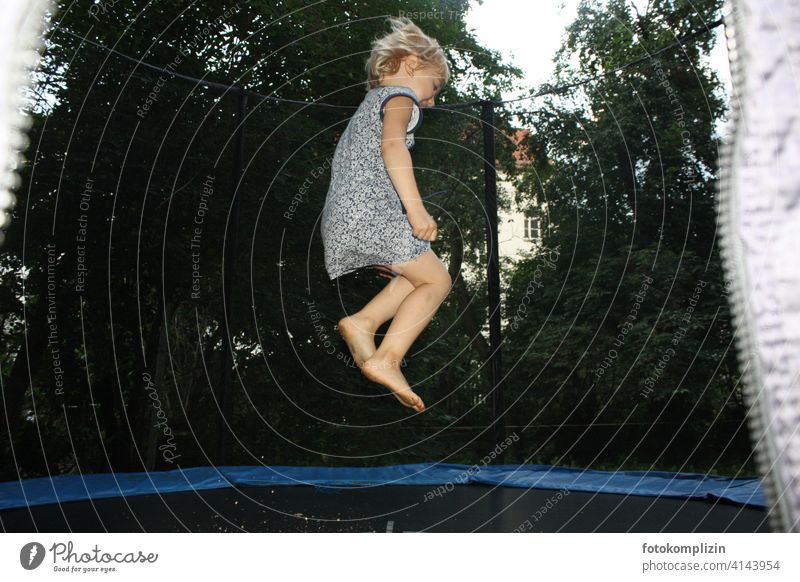 Kind hüpft auf einem Trampolin hüpfen Luftsprung Kinderspiel energiegeladen vitalität Freizeit & Hobby turnen fröhlich sich bewegen luftig Freude Sprung