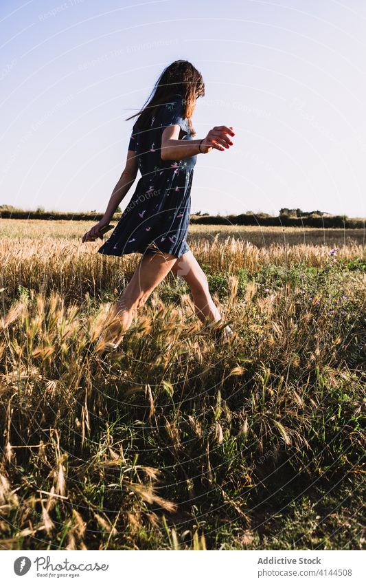 Fröhliche Frau geht am Feld entlang laufen Landschaft sorgenfrei Wochenende Sommer sonnig Freiheit heiter Gummi Stiefel Kleid Sonne Freude Wiese Natur Harmonie