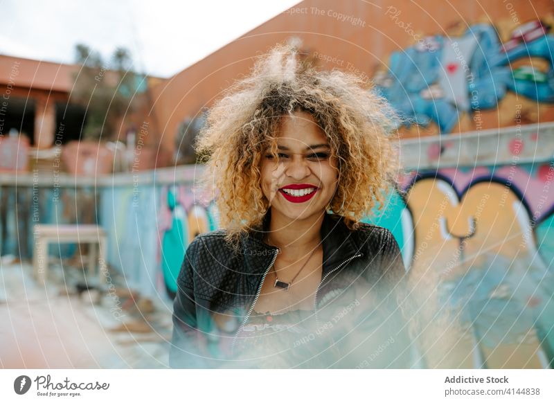 Positive schwarze Frau in der Stadt tausendjährig urban Großstadt Graffiti Outfit Afro-Look heiter Generation Stil ethnisch Afroamerikaner Frisur Glück Straße